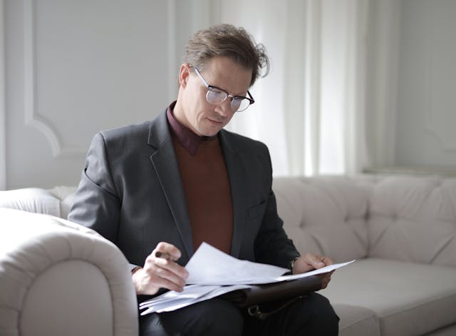 a person sitting on a couch reviewing a document