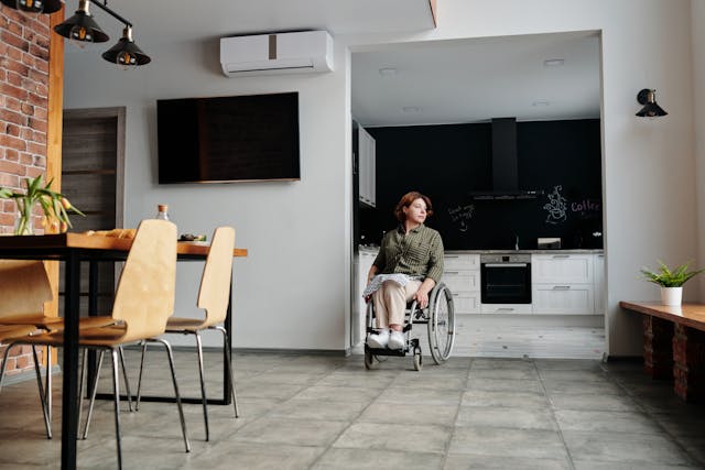 person in a wheelchair in their apartment’s kitchen