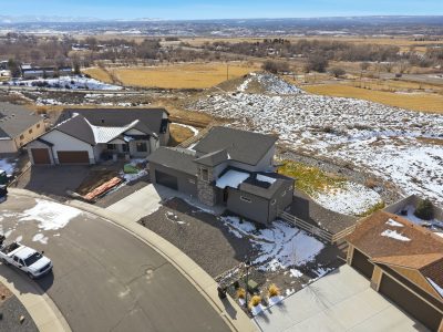 Drone aerial view of a custom-built home for sale in Montrose, Colorado with San Juan Mountain views