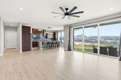 Living room with large windows and mountain views in a custom home for sale in Montrose, Colorado